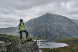 Hiker taking in the view on the edge of a stone ledge with lake in background. Ross Woodhall - Action & Lifestyle Photography