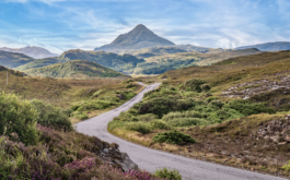 Looks like a road leading to a mountain with heather on the roadsides Ross Woodhall - Action & Lifestyle Photography