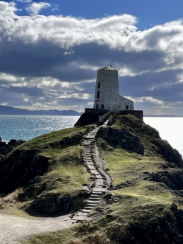 Old lighthouse on the hill with a sandy path leading up to it with the ocean & distance coast line in the background. Ross Woodhall - Action & Lifestyle Photography